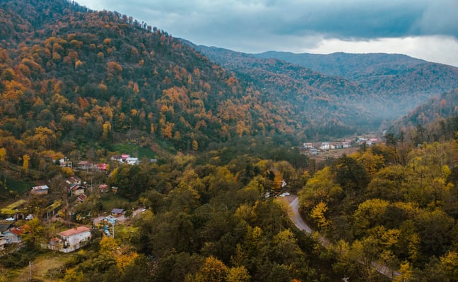 Aerial view of a small mountain town surrounded by autumn foliage